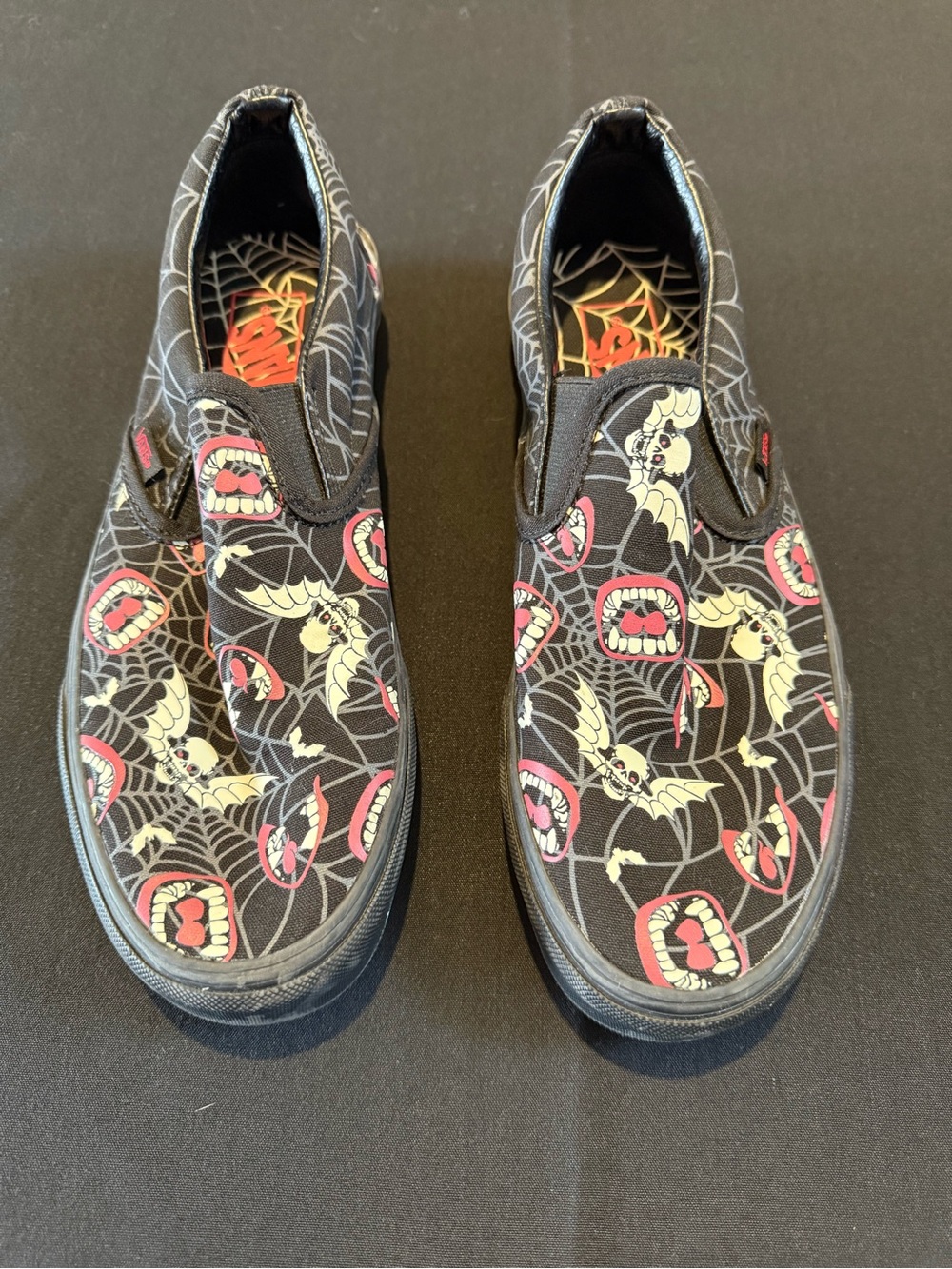 Vans Black Slip-On Sneakers with Spiderweb Insole and Red Bat Accents